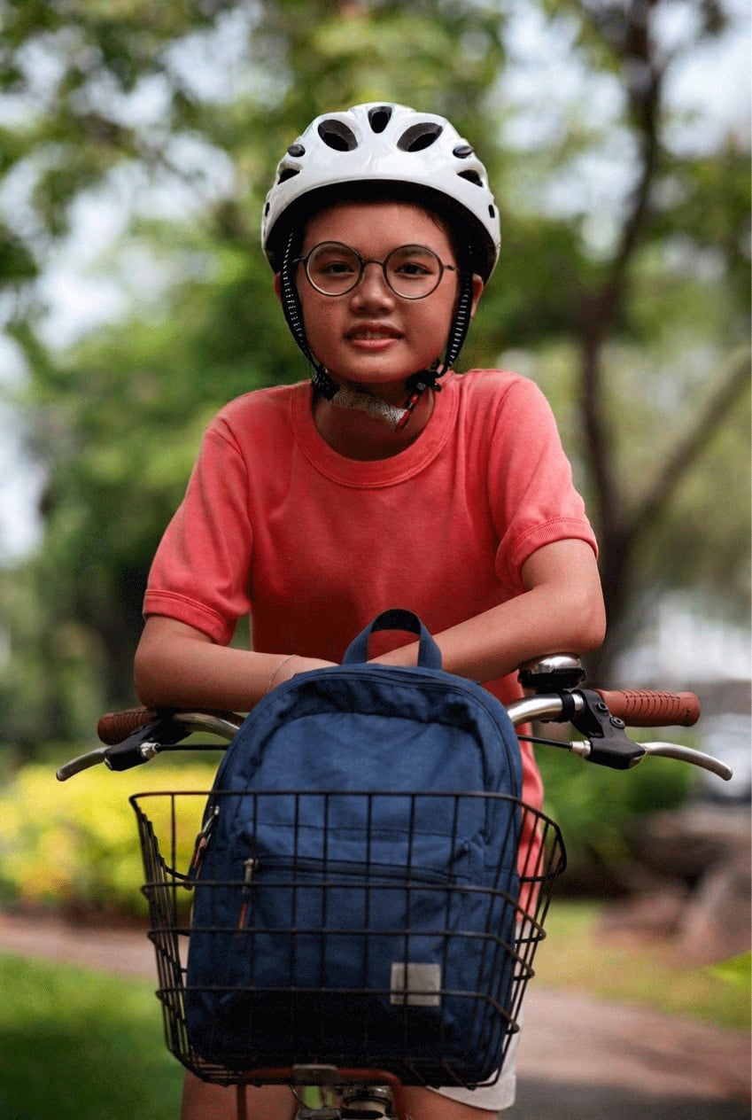 young male on a bicycle wearing a helmet