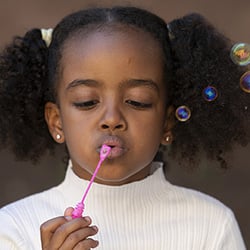 girl blowing bubbles